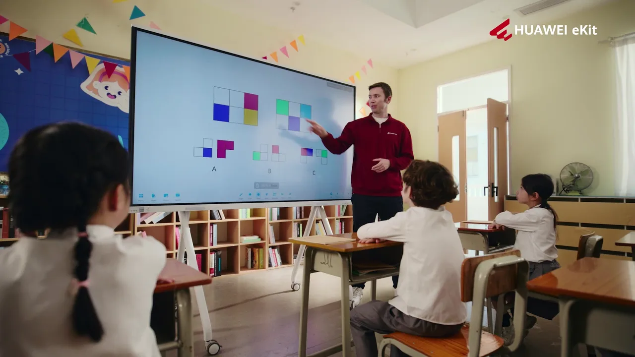 Maestro escribiendo en la pizarra de Huawei IdeaHub Board 3 Pro frente a su grupo